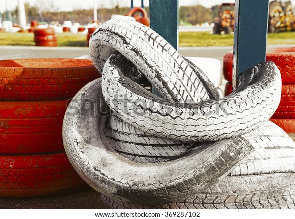 Fencing of the tires on a\
racing kart track. Old tires from the car in the form of obstacles\
in karting
