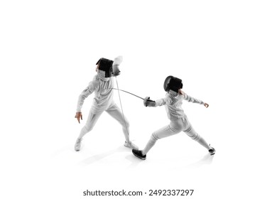 In fencing training session, two female competitors work on their attack and parry sequences against white studio background. Concept of professional sport, competition, strength and power, action. Ad - Powered by Shutterstock