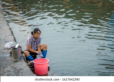 Feng Huang, China -  August 2019 : Old Woman Doing Laundry On The Riverbank Of Tuo River,  Feng Huang Old Town