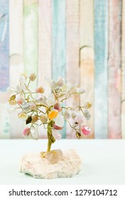 Feng Shui Gem Tree, Also Called Feng Shui Crystal Tree Is Used For Spiritual Feng Shui Cures For Love To Feng Shui For Money. Isolated On Colorful Pastel Wooden Board Background.