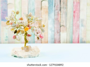 Feng Shui Gem Tree, Also Called Feng Shui Crystal Tree Is Used For Spiritual Feng Shui Cures For Love To Feng Shui For Money. Isolated On Colorful Pastel Wooden Board Background.