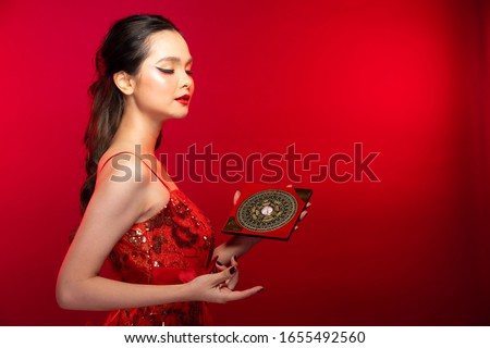 Feng Shui Master Red Woman show FengShui Compass and turn direction to Force Energy, Many Chinese Texts on Compass translate as North South West East Luck Prosperity on Wind Water elements Flow