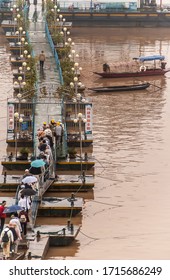 Fengdu, China - May 8, 2010: People Walking On Narrow Pontoon Bridge To Their Boat At Yangtze River Terminal. Brown Water And A Couple Of Sloops.