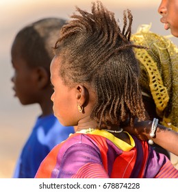 FERLO DESERT, SENEGAL - APR 25, 2017: Unidentified Fulani Little Girl With Braids Looks Ahead. Fulanis (Peul) Are The Largest Tribe In West African Savannahs