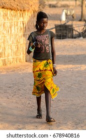 FERLO DESERT, SENEGAL - APR 25, 2017: Unidentified Fulani Girl With Braids Walks Along The Street. Fulanis (Peul) Are The Largest Tribe In West African Savannahs