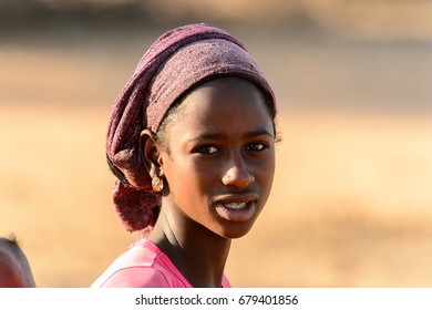 FERLO DESERT, SENEGAL - APR 25, 2017: Unidentified Fulani Woman In Headscarf Stands On The Street. Fulanis (Peul) Are The Largest Tribe In West African Savannahs