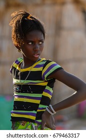 FERLO DESERT, SENEGAL - APR 25, 2017: Unidentified Fulani Girl With Braids In Colored Clothes Looks Away. Fulanis (Peul) Are The Largest Tribe In West African Savannahs