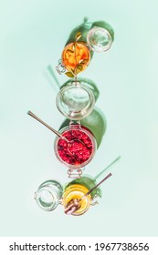 Fermentation and storage of fruits, vegetables and berries. Food composition with glass jars with fermented honey cranberries, lemon and carrot on mint background. Homemade natural remedy for immunity