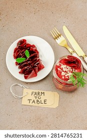 Fermented beetroot pasta salad in a jar with sliced beets. Probiotics and healthy plant-based eating, farm to table concept, homemade food. Warm brown background, top view