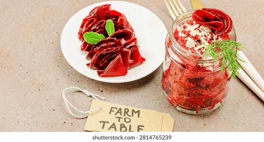 Fermented beetroot pasta salad in a jar with sliced beets. Probiotics and healthy plant-based eating, farm to table concept, homemade food. Warm brown background, banner format