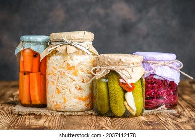 Fermented foods. Sauerkraut, red cabbage, cucumbers and carrots on a rustic background. - Shutterstock ID 2037112178