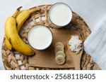 Fermented kefir drink with probiotics, kefir grains on a wooden spoon, kefir prepared with banana and honey.