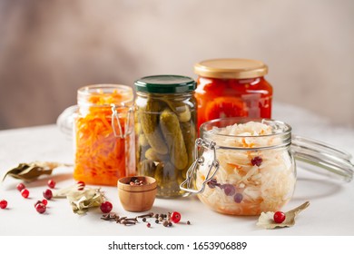 Fermented Preserved Vegetables Food Concept. Glass Jars With Fermented, Pickled And Canned Vegetables  On  Kitchen Table. Conservation Of Farm Organic Seasonal Harvest. Healthy Homemade Food