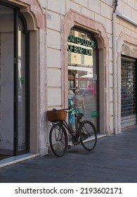 Ferrara, Italy - August 14, 2022. Bike Parked Next To A Clothing Store Window.