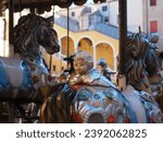 Ferrara, Italy. Piazza Municipale, in the foreground a vintage horse-drawn carousel, in the background the staircase of the ducal palace.