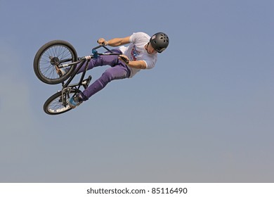 FERRARA, ITALY - SEPTEMBER 17: BMX Bicycle Freestyle - Unidentified Stunt Biker Makes A Jump On Blue Sky Background At Ferrara Balloons Festival On September 17, 2011 In Ferrara, Italy