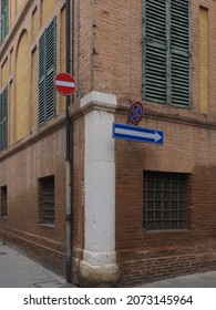 Ferrara, Italy. Street Corner, Old Building With Green Shuttered Windows. No Entry Sign, No Stopping Sign, One Way Arrow.