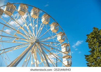 Ferris wheel against the sky with clouds, illuminated by the rays of the setting sun. Crikvenica, Croatia 