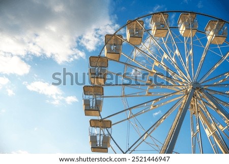 Ferris wheel against the sky with clouds, illuminated by the rays of the setting sun. Crikvenica, Croatia 