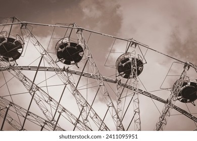 Ferris wheel in amusement park against blue sky background with sepia filter