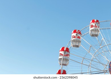 Ferris wheel in amusement park on blue sky background