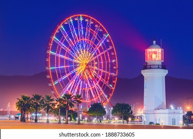 Ferris Wheel At Amusement Theme Park In The Evening Time. Batumi Boulevard. Photo Is Taken With A Long Exposure And Has Motion Blur. 