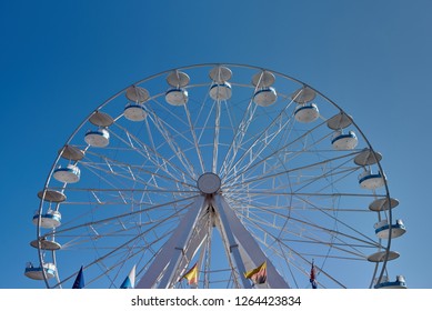 Ferris Wheel With Flags Of Several Country In Amusement Park. Front View Image.