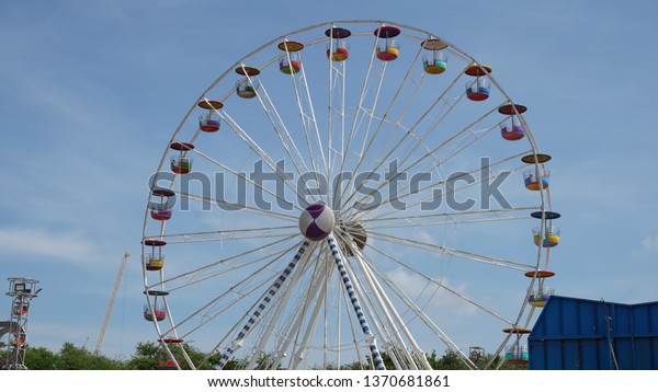 A Ferris wheel or a giant wheel is an amusement
ride consisting of a rotating upright wheel with multiple
passenger-carrying components (commonly referred to as passenger
cars, cabins, tubs, capsules,