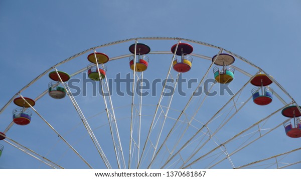 A Ferris wheel or a giant wheel is an amusement\
ride consisting of a rotating upright wheel with multiple\
passenger-carrying components (commonly referred to as passenger\
cars, cabins, tubs, capsules,