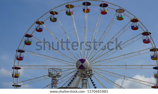 A Ferris wheel or a giant wheel is an amusement\
ride consisting of a rotating upright wheel with multiple\
passenger-carrying components (commonly referred to as passenger\
cars, cabins, tubs, capsules,
