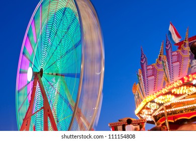 Ferris Wheel Lights And Colors Motion Blur Against Twilight Sky