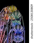 A ferris wheel is lit up in multi colour at night at Fun Spot America (Old Town) in Kissimmee near Orlando, Florida.