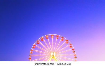 Ferris wheel of multi-color on cloudy sky background, over toning and select focus. Background or copy space. - Powered by Shutterstock