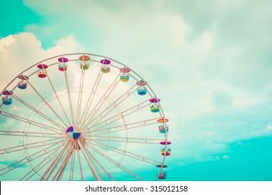 Ferris wheel on cloudy sky background vintage color