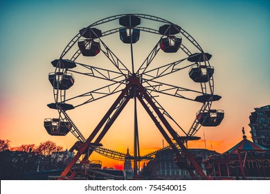 Ferris wheel Silhouette at sunset against the colorful evening skyline at dusk - popular children attraction in park. Vintage retro toning filter - Powered by Shutterstock