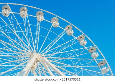 Ferris wheel structure against clear blue sky, sunny day, city park - Powered by Shutterstock