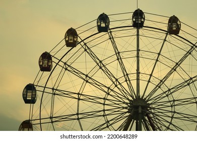 Ferriswheel landscape in the corner of Indonesian city at dusk