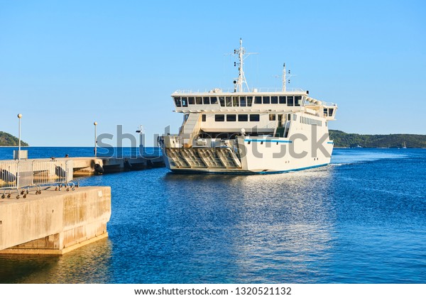 Ferry boat\
arriving at a port with open\
gates