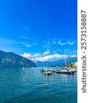 Ferry dock in the town of Iseo on sunny summer day. A small pier along the shore of Lake Iseo, Lombardy, Italy.