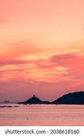 A ferry passes the genoese tower at the Pointe de Parata in les Iles Sanguinaires near Ajaccio in Corsica at sunset