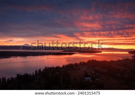 Ferryboat crossing Hale Pass from Lummi Island to Gooseberry Point during a spectacular sunrise. Bellingham Bay and Mt. Baker can be seen in the background. Dramatic clouds make this image special.