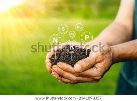 The fertile soil for cultivation is in the hands of men, and there are technology icons about the elements in the soil. Soil for planting with the nutrients in the soil that are necessary for plant.