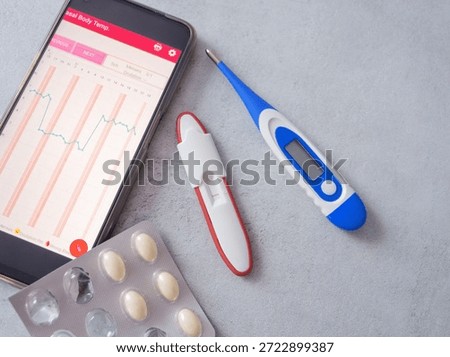 Fertility tracking tools, including a BBT thermometer, an app displaying a temperature chart, and supplements for pregnancy planning. A modern approach to women's reproductive health.
