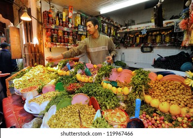 FES - MARCH 10: Unknown Man Trades A Green Olives In A Market (souk) In A City Fes In Morocco. The Market Is One Of The Most Important Attractions Of The City. March 10, 2012 Fes, Morocco.