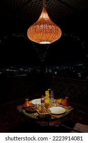 Fes, Morocco - September 01, 2022; Dinner Table With Wicker Lamp At Night In The Terrace Of A Riad