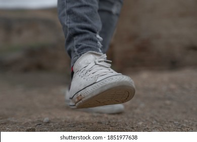 
Fes/Morocco - November 06, 2020; Man With Gray Jeans And White Converse And Multi-colored Socks Walking Stepping Forward With His Right Leg