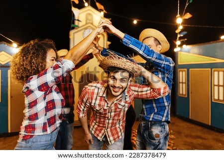 Festa Junina in Brazil. Group of friends dancing the Brazilian square dance.