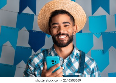 Festa Junina: party in Brazil, portrait of man with mobile phone at June Festival in caipira clothes - Powered by Shutterstock