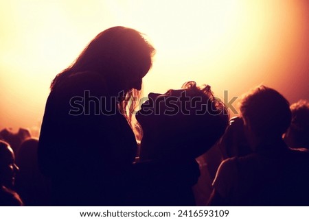 Festival, concert and couple dance at night together with happiness and energy from stage lights and music. Club, party and silhouette of people with love and embrace in dark at disco, date or rave