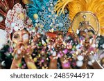 Festival, confetti and portrait of women in Brazil with costume, blowing kiss and party in city. Carnival, show girls and glitter at parade for performance, culture and traditional samba dancers